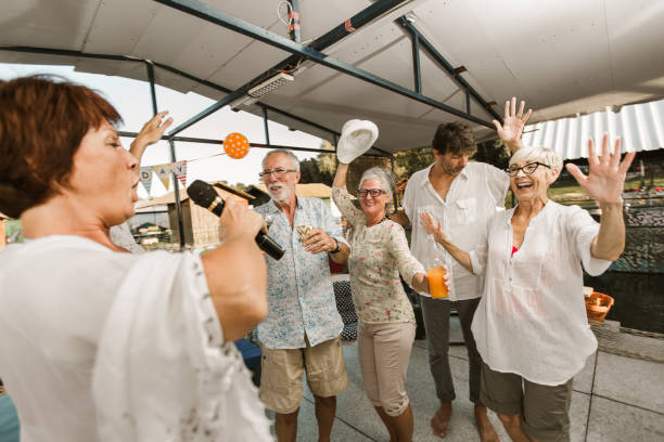 istock Senior people celebrating birthday singing karaoke. 1308416284