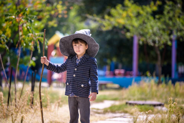 istock Toddler boy in pointed hat playing with magic wand outdoors. Little wizard. Halloween concept 1308416687