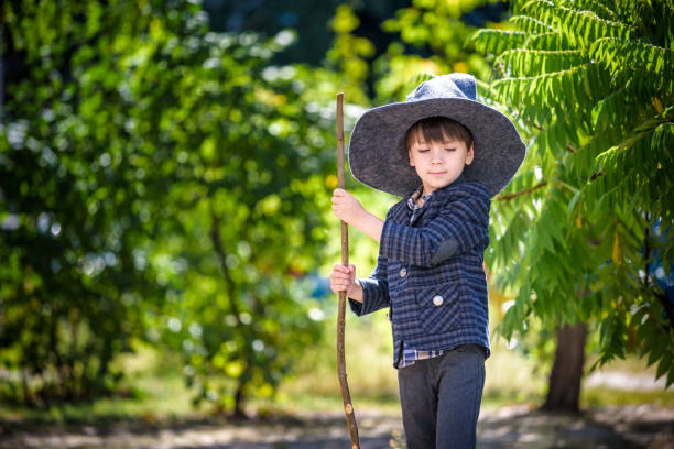 istock Toddler boy in pointed hat playing with magic wand outdoors. Little wizard. Halloween concept 1308416786