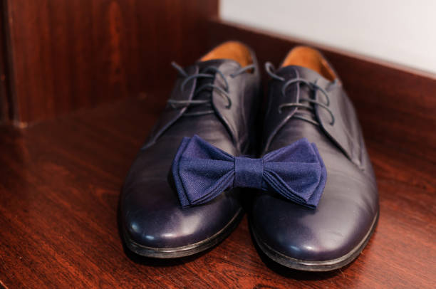 papillon blu su scarpe classiche blu su sfondo marrone - shoe groom wood luxury foto e immagini stock