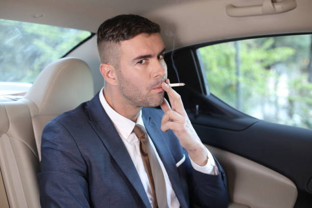 istock Businessman smoking in back seat 1308420166