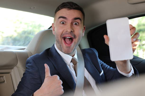 istock Elegant back seat passenger showing screen 1308420345