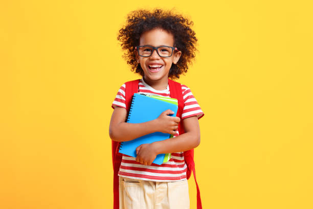 istock Happy schoolkid laughs at camera standing in studio with copybooks in hands 1308420664