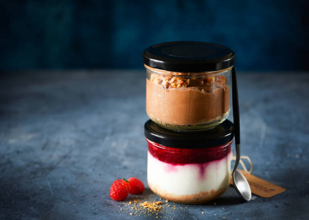 istock Two homemade easy cheesecakes in jars with chocolate mousse and raspberry curd sauce on a dark blue background. Healthy dessert. Selective focus. Homemade Raw Vegan Pudding. 1308420787