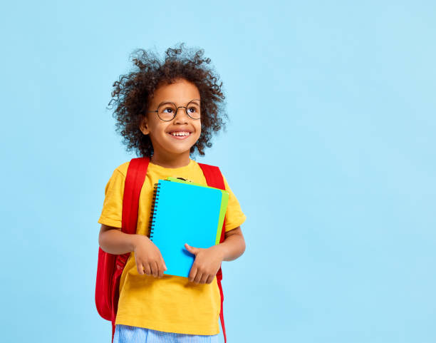 istock Happy schoolkid smiled and looking away standing in studio with 1308420837