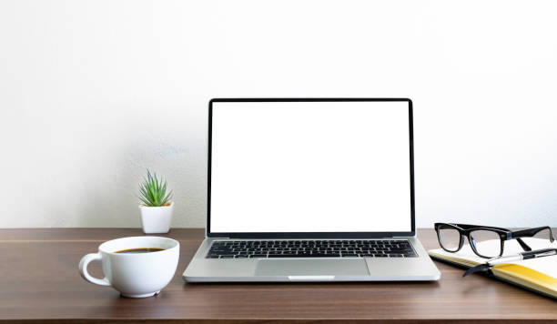 istock Laptop computer blank screen on wood office desk table with coffee cup and notebook, mouse computer with equipment office supplies. Business and finance concept. Workplace, Flat lay with copy space. 1308423324