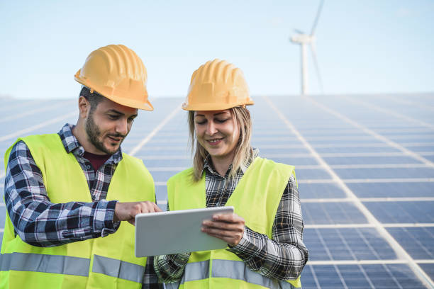 jeunes travaillant avec la tablette numérique à la ferme d’énergie renouvelable - focus sur les visages - solar panel engineer solar power station women photos et images de collection