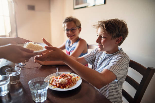 istock Little boys enjoying spaghetti lunch 1308423845