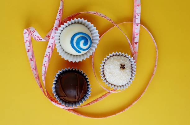 istock Chocolate truffles and a measuring tape. Diet concept. 1308423869