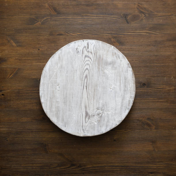 istock grunge empty round wooden plate on old wooden table 1308426141