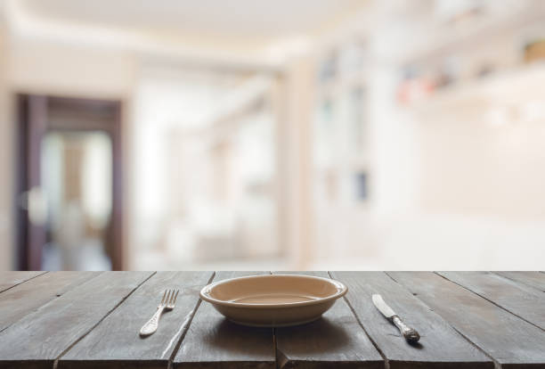istock empty plate with fork and knife on wooden table 1308426795