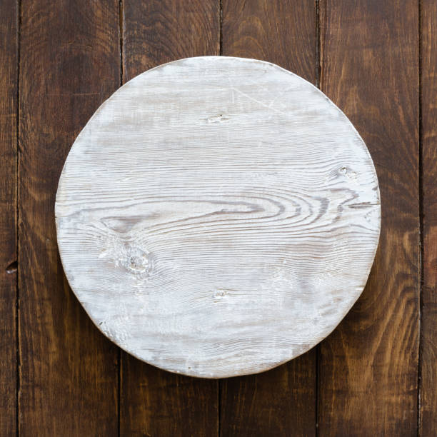 istock grunge empty round wooden plate on old wooden table 1308427621