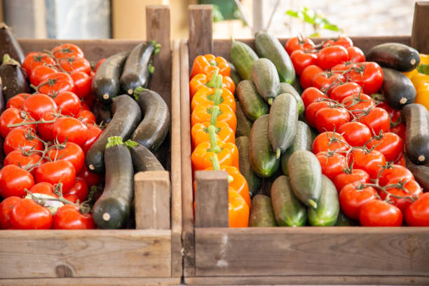 Fresh vegetables, tomatoes, eggplant, peppers, cucumbers and zucchini in a wooden box
