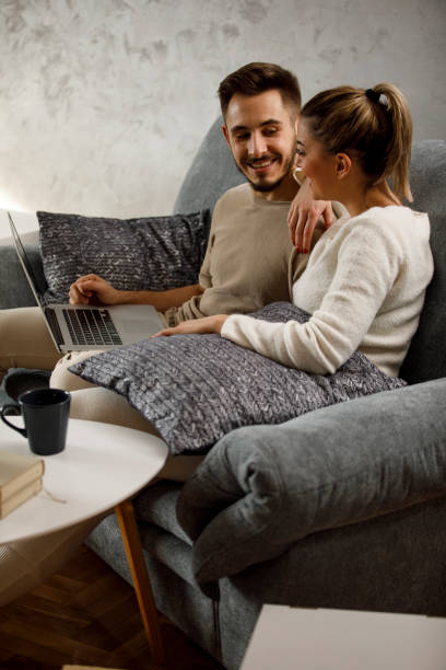 istock Couple relaxing on the sofa together and using laptop 1308429254