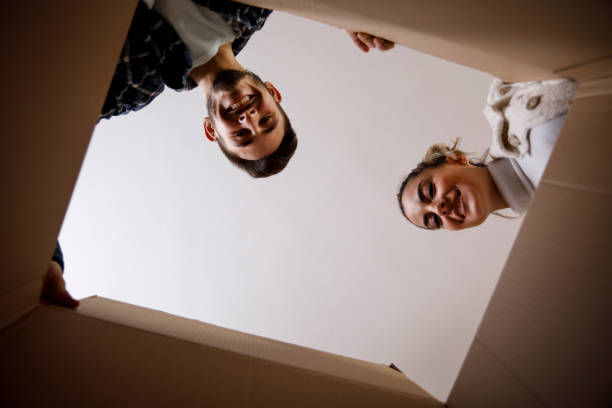 istock Smiling couple unpacking a box in a new apartment 1308429316