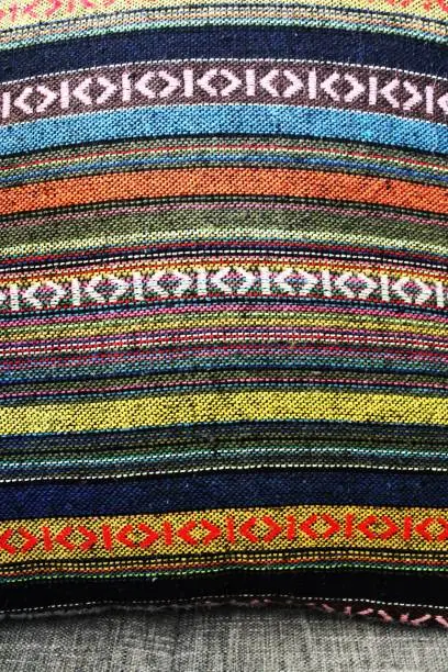 Colorful bands of woven fabric adorn this throw pillow.