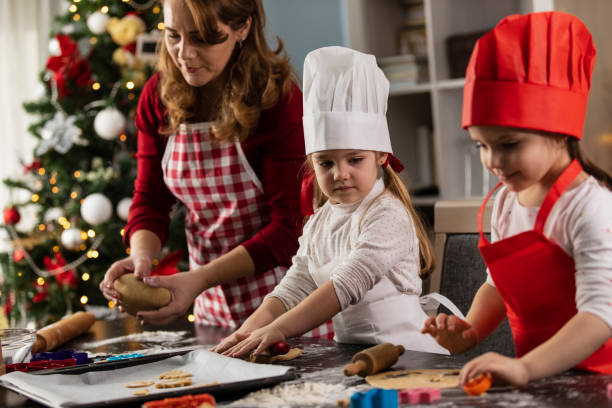 istock Woman making gingerbread cookies with her two little daughters 1308431506