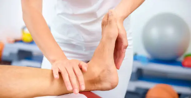 Photo of Close-up of woman massaging mature man's foot