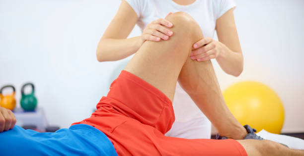 istock Young woman massaging mature man's knee 1308431650