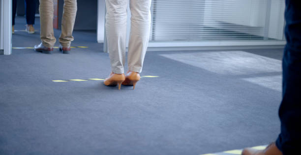 istock Business people standing behind social distancing signage 1308432452