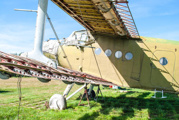 istock Small old plane standing in summer green field 1308433597