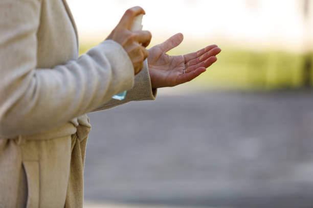 istock Unrecognizable woman holding a disinfecting spray and sanitizing her hands 1308433858