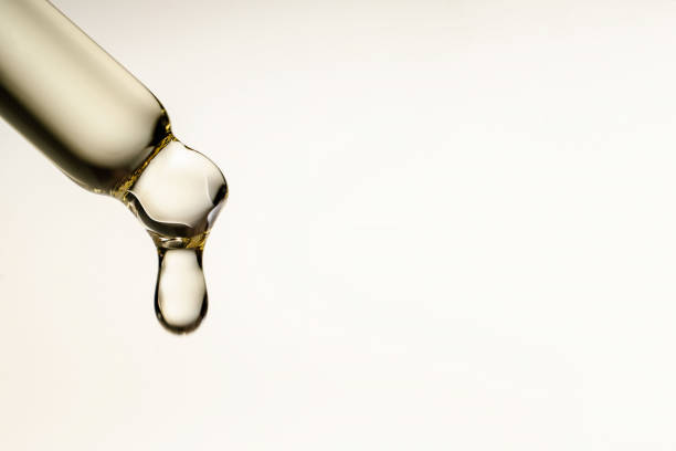 une goutte d’huile cosmétique tombe de la pipette - prélèvement de sérum photos et images de collection