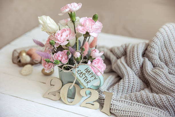 istock Easter composition with fresh flowers in a vase, a knitted element and the inscription Happy Easter on the card. 1308435708