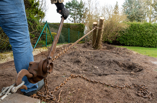 Removing a tree stump with a hoist in the garden.