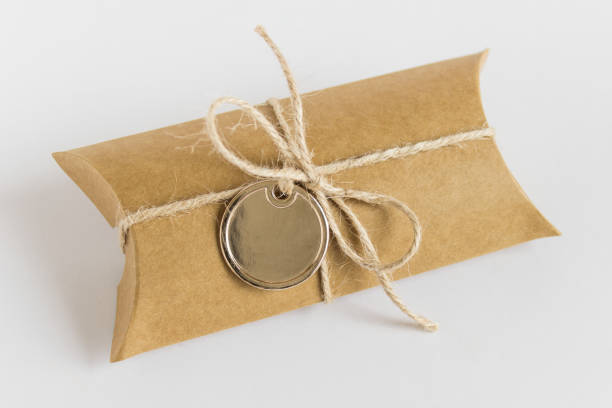 istock Present craft paper box wrapped with packthread and golden round metallic label 1308437045
