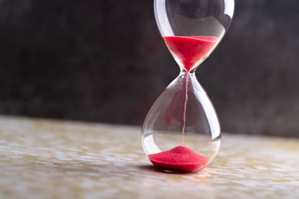 istock Sand passes through hourglass bulbs measuring the transit time counting down to the deadline, against a dark background 1308437150