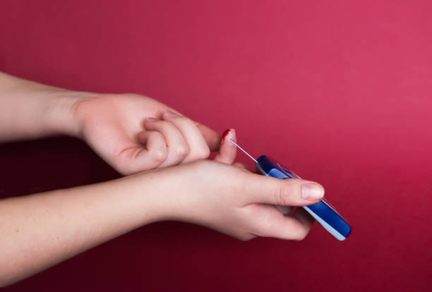 Man using a glucometer checking blood sugar levels. Diabetes concept on red background. emphasis on the problem of early detection and prevention of disease. empty space for information