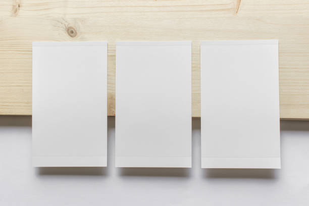 Mockup template with three vertical blank photo cards on wooden and white paper background.