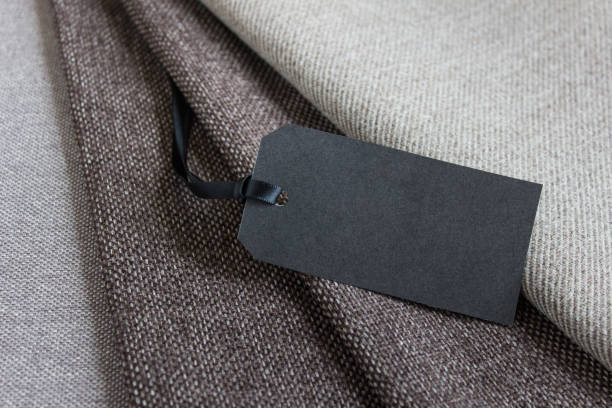 istock Black blank price tag on dark brown fabric layers 1308438906