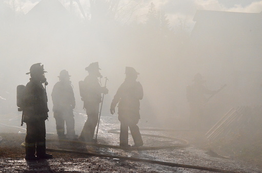 Silhouettes of firefighters through the smoke