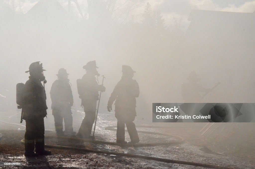 Firefighters Silhouettes of firefighters through the smoke Firefighter Stock Photo