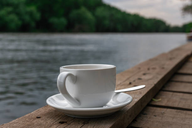 istock A white cup of drink in a blurry riverside view landscape background 1308442075
