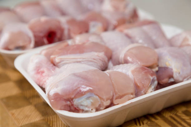 istock Chicken drumsticks frozen in a container on a wooden cutting board 1308442921