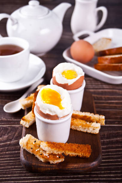 istock boiled egg in eggcup on wooden board with crispy toast. 1308443285