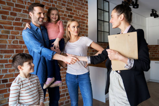 family shaking hands with real estate agent in new apartments - family insurance agent real estate financial advisor imagens e fotografias de stock