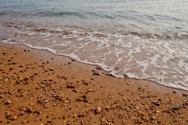 istock Small waves on the sea beach at the lately evening for backdrop background with red sand 1308445524