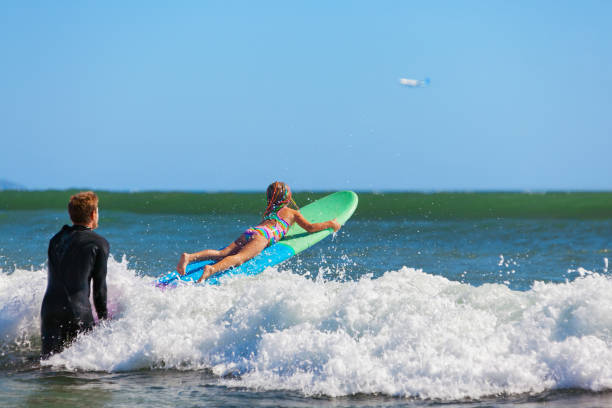 istock Young surfer learn to ride on surfboard with surf instructor 1308446669