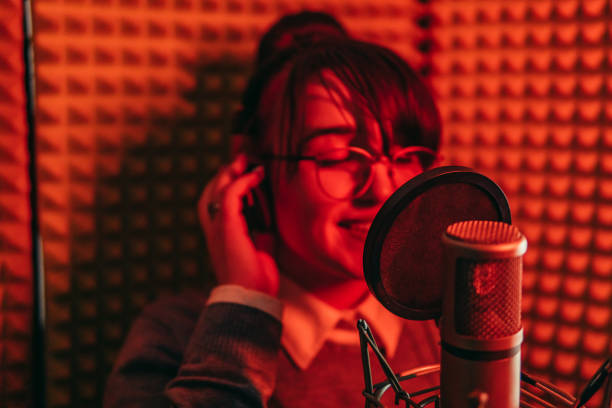 istock Woman singing to microphone in studio 1308447781