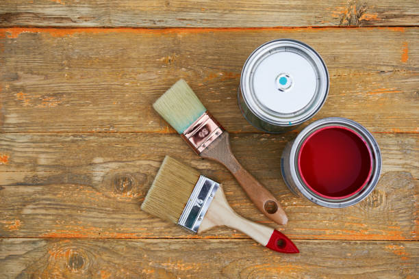 istock Paint cans and brushes on the old wooden background. 1308448381