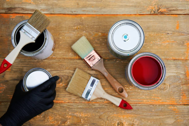 istock Paint cans and brushes on the old wooden background. 1308449823