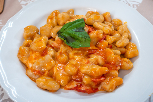 A plate full of Gnocchi with tomato mozzarella and basil