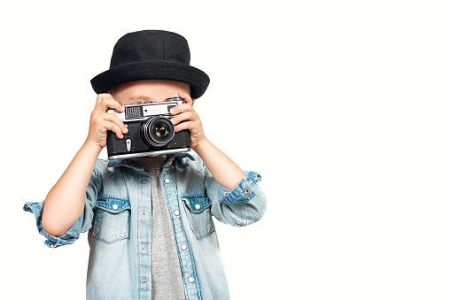 Photographer taking a photo with vintage retro camera isolated on a white background. Film, retro. Stylish kid