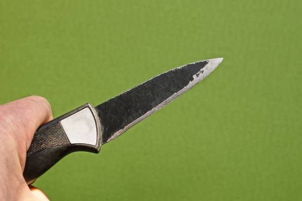 istock hand holds a black old knife 1308454689