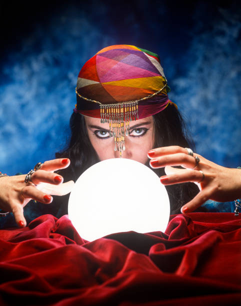 fortune teller with glowing crystal ball Gypsy fortune teller with glowing crystal ball on red velvet fortune teller photos stock pictures, royalty-free photos & images