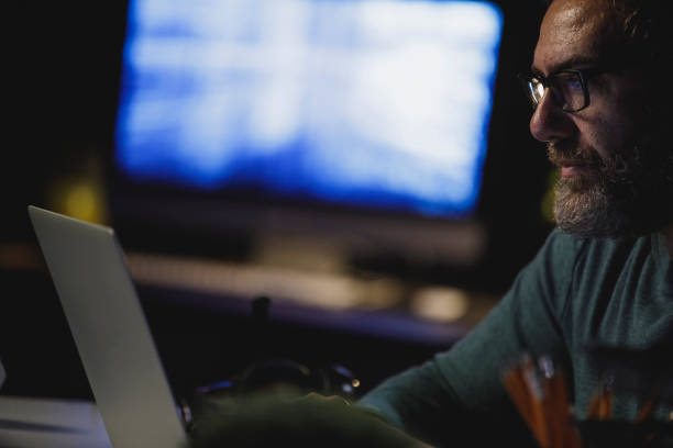 istock Copy space shot of mature man concentrating while using laptop and working late 1308454934